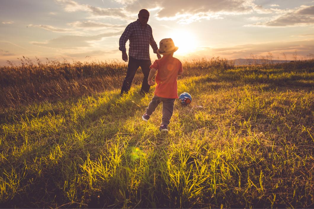 sunset kid and grandparent playing soccer