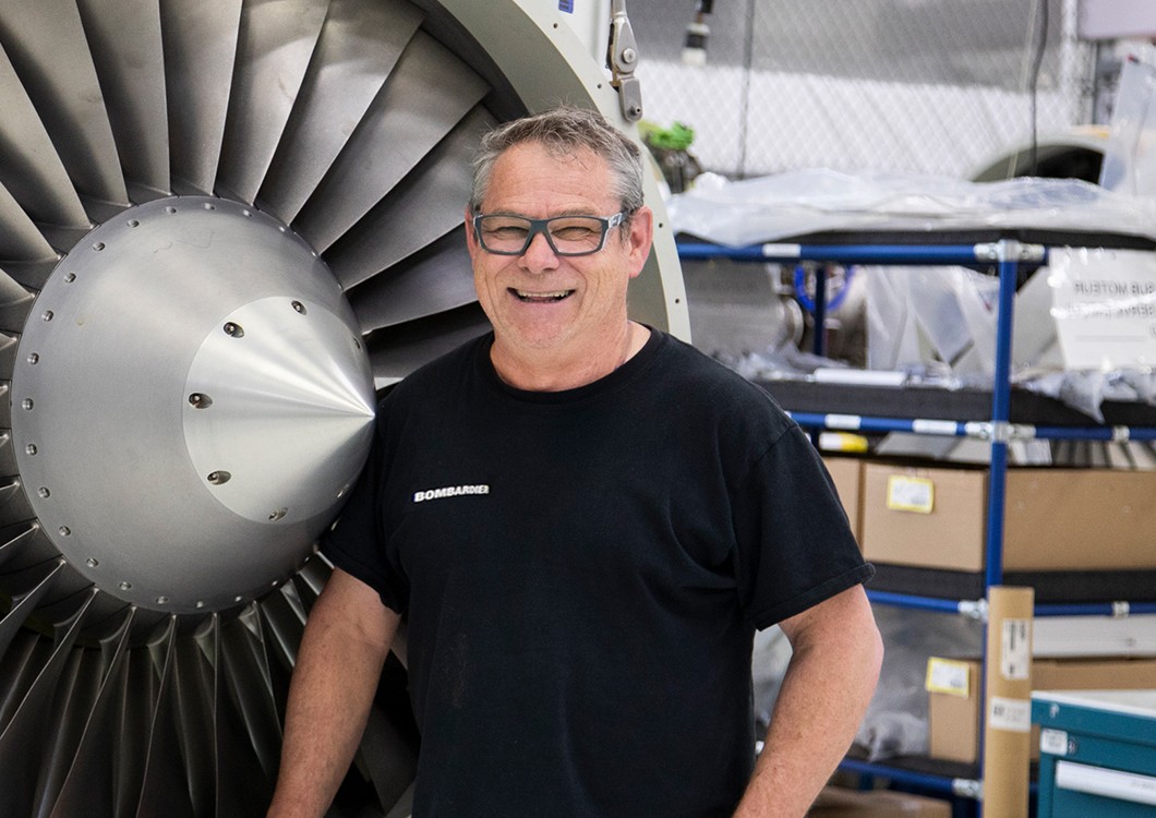 male worker standing in front of aircraft engine