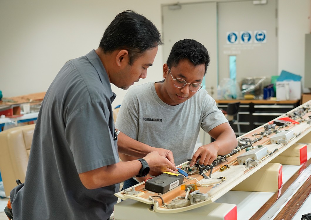 two workers tinkering with an interior aircraft part