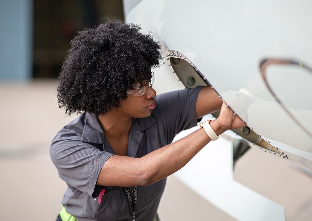 female employee working on the exterior of an aircraft