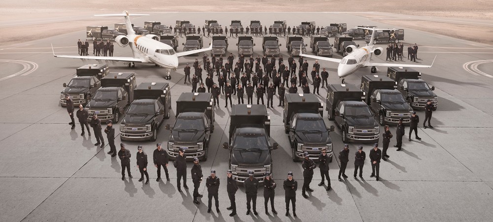 mobile response team standing on a runway in an orderly manner with trucks sitting idly behind them