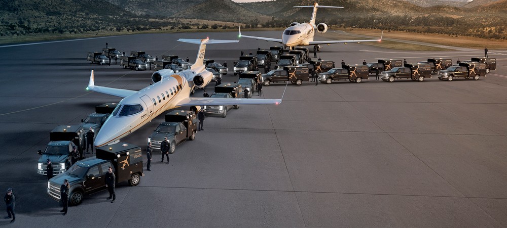 group of workers on a tarmac with an aircraft and trucks